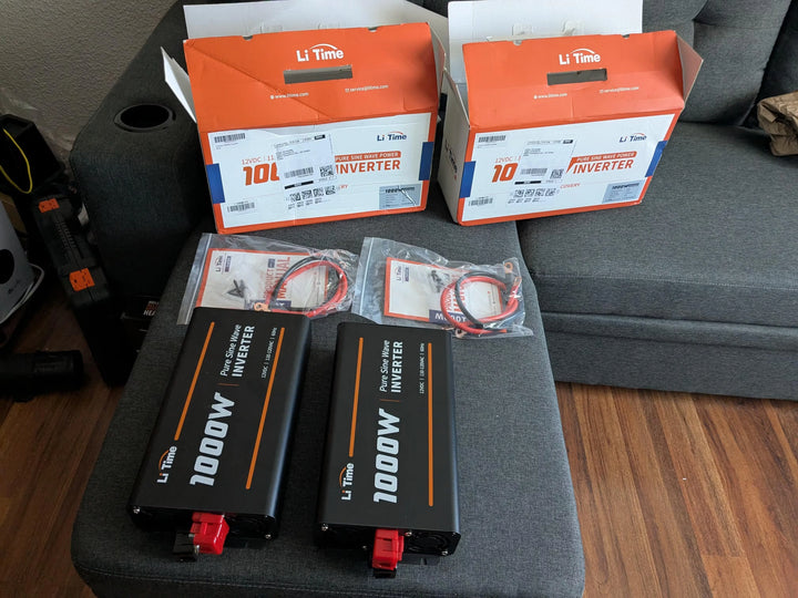 Two black Li-Time 1000W pure sine wave inverters on a gray couch.
