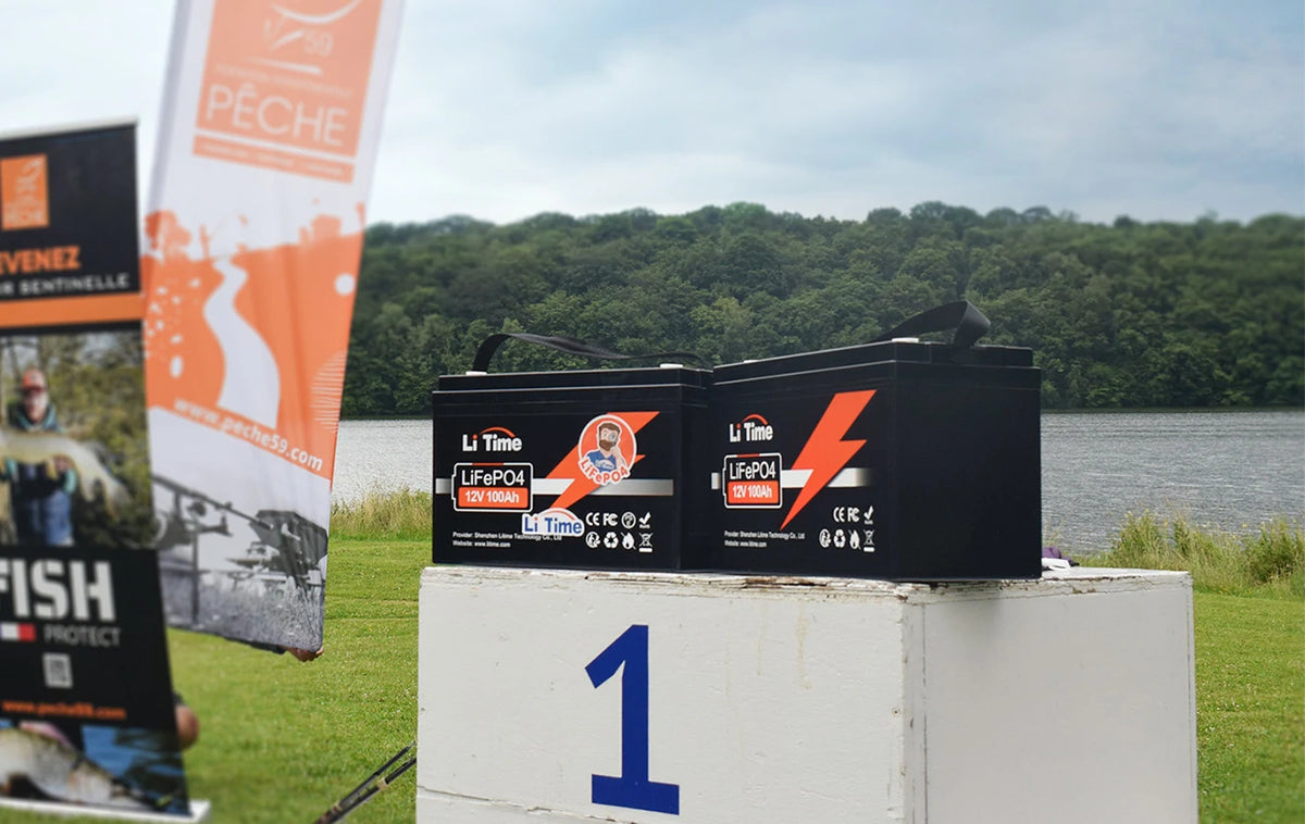 Two LiTime 100Ah batteries sit on the first-place block of a winners' podium at the Peche Fishing Game event