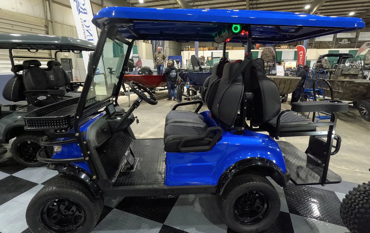 a golf cart with rugged wheels on display at the JDM Show
